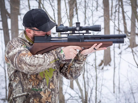 Person aiming Viriatus 2.0 BP PCP Air Rifle 177 Caliber With 1020 FPS Velocity And Lothar Walther Barrel in snowy forest