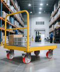 Heavy Duty Industrial Caster Wheels With 5000 Pound Capacity Polyurethane Treads And Cast Iron Cores Swivel Plate on a yellow cart in a warehouse setting.