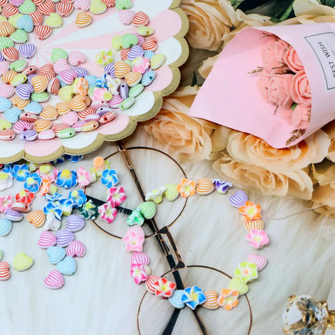 Close-up of Frangipani Flower Beads Set 50Pcs 12mm Polymer Clay Plumeria Floral Beads Assorted Colors on craft table.