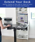 Boss Move Heavy Duty Clamp On Desk Extender With Foldable Keyboard Tray And Padded Wrist Support Expands Workspace For Sit Stand Tables Smooth Setup All Day Grind Black in use with laptop and monitor setup.