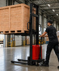 Worker using Rock Solid 6000 Lbs Heavy Duty Semi Electric Pallet Stacker with adjustable steel forks in a warehouse.