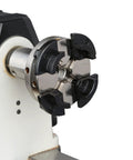 VINWOX 4-inch four-jaw self-centering wood lathe chuck, front view, black jaws on silver body mounted to spindle.
