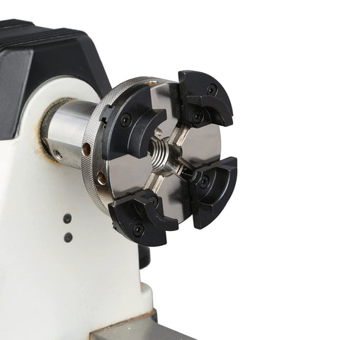 VINWOX 4-inch four-jaw self-centering wood lathe chuck, front view, black jaws on silver body mounted to spindle.