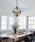 Rustic Farmhouse Chandelier 14-Inch Globe Pendant Light In Vintage Black And Gold hanging in a cozy dining room setting