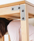 Heavy Duty L Shaped Corner Brackets Set, 36 Stainless Steel Mounting Braces for Cabinets and Furniture securely attached to wooden table corner.