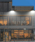 Beast Bright 150W LED Wall Pack Light With Photocell illuminating cafe facade, showcasing 19,500 Lumen Output, 5000K Daylight.