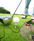 Golf Tee Anchor Kit With 4 Ground Stakes And Durable Bungee Cords Keeps Tees In Place For Consistent Swings No More Lost Tees Includes Stake Puller Tool Perfect For Practice Rounds At The Range Or Backyard Wind Resistant Tee Lock shown in use with driver and ball on grass.