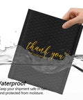 Hand holding Black 4x8 Inch Bubble Mailers 50 Pack Padded Envelopes with waterproof feature for secure shipping in water.