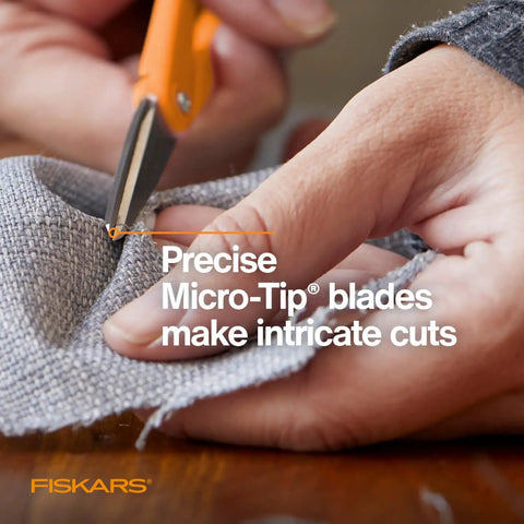 Hands using Premier No 5 Micro Tip Orange Handled Fabric Scissors With Double Loop Handle for precise cuts on fabric.