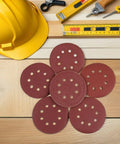 Premium 150 Piece Inch 8-Hole Hook And Loop Sanding Discs Assorted Grits 40 To 800 on a wooden surface with tools.