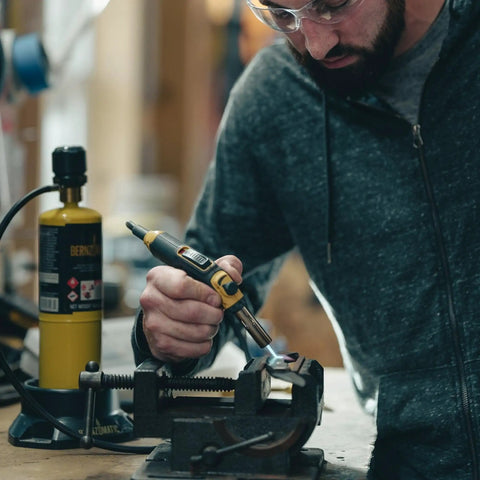 Person using Pro Grade Precision Flame Hand Torch With Adjustable Heat For MAP Pro Propane Fuel on metal project in workshop.