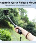 Person holding a selfie stick with Magnetic Quick Release Adapter Mount for Insta360 GO Ultra in outdoor setting.
