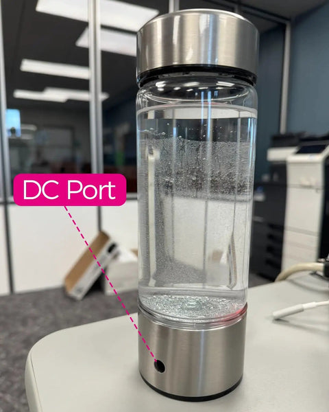 Hydrogen Water Generator Bottle Charging Cable USB To DC Charger Cord connected to DC port on bottle, shown in office.