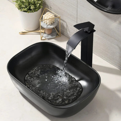 Black Rectangle Vessel Sink 18x13 Above Counter Porcelain Ceramic With Faucet And Drain Combo Dope Durable Porcelain Triple Glaze Finish Scratch Resistant Modern Bathroom Vessel Basin shown installed with water flowing