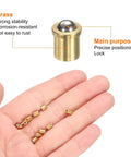 Top Shelf Brass Ball Spring Plungers Ten Pack Four By Five Millimeters with main plunger and smaller pieces in hand.
