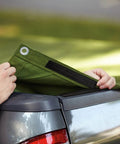 Person using Beefy Black Scotch Extreme Fasteners 10 Ft By 1 In Heavy Duty Velcro Bond on green tarp over truck bed