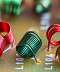 Close-up of Ten Pack FR4 Dope Double Sided Copper Clad PCB Boards with colorful coils for DIY electronics etching and prototyping.