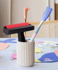 Solid Grip Rubber Paint Roller For Printmaking And Classroom Art Projects in a holder with pencils and craft materials.