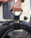Person holding cable secured with Garage Organization Value Pack With Assorted Storage Straps For Cords And Hoses Cable Management Essentials