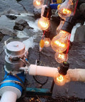 1000W Micro Hydro Generator For Outdoor Use Hydroelectric Water Turbine With 220V Output Portable Water Powered Generator For Camping And Off Grid Power Ready To Go installed by river with glowing bulbs