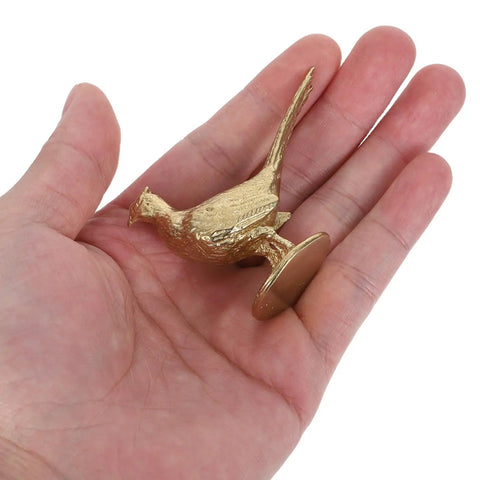 Top Shelf Brass Pheasant Drawer Knob With Rich Golden Finish held in hand, showcasing intricate design and tarnish-proof material.