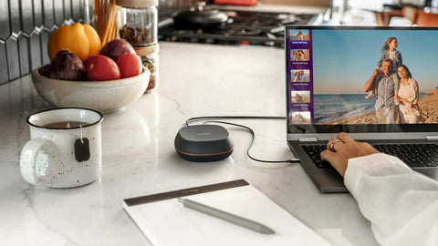 Person using laptop connected to Massive 8TB External SSD Desk Drive With USB-C And USB 3.2 Gen 2 on a kitchen counter.
