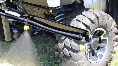 Quick Detach Sprayer Nozzle Caps With Gaskets 2 Pack attached to flat fan nozzles demonstrating spray system on boom.
