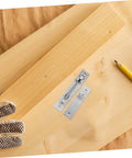 Close-up of hidden pivot hinge set on wood surface with pencil, highlighting 180-degree design for concealed applications in doors and cabinets.
