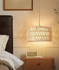 Level Up Your Chill Zone With This Hand Woven Rattan Plug In Pendant Light Farmhouse Hanging Lamp featuring warm glow over bedside table.