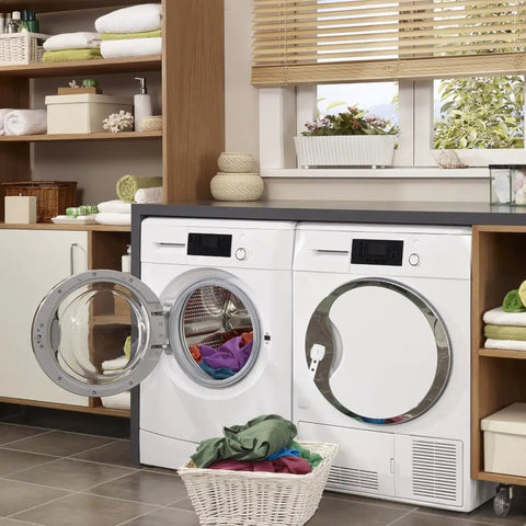 Laundry room with two white front-loading washers, towels, and laundry basket in a bright and organized space.