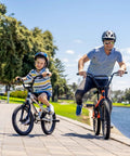 Father and son cycling by a lake on 20 inch bikes, showcasing Bombproof 20 Inch Bike Inner Tube with 32mm Schrader Valve.