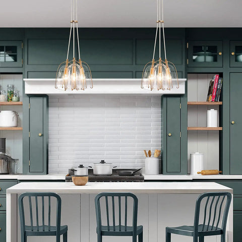 Gold Modern 3-Light Pendant Chandelier with Seeded Glass Shades above kitchen island with teal cabinets and white backsplash.