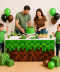 Two Pack Pixel Miner Party Table Skirts With Classic Green And Brown Block Pattern For Sick Gamer Birthday Decorations and Next Level 8 Bit Video Game Themed Party Supplies That Bring Ultimate Arcade Vibes To Your Party Table Setup. Family celebrates with cake at pixel-themed setup.