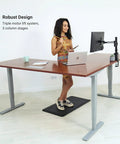 Level Up Your Setup With This Bad Boy Electric L Shaped Standing Desk In Roasted Walnut And Black Frame 83X55 Inch Extra Large Corner Workstation Height Adjustable Sit Stand with a woman using it.