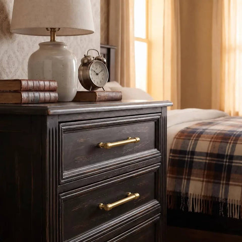 Top Tier Brushed Brass Cabinet Pulls 10 Pack Featuring 96MM Hole Spacing on a nightstand with books and lamp