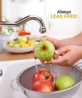 Person washing apples under a lead-free faucet in a kitchen sink