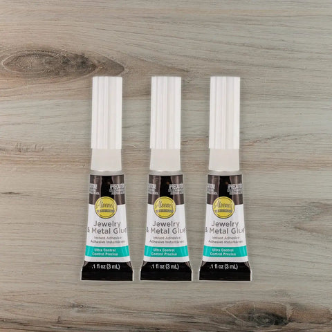No Drip Instant Jewelry Glue Waterproof Adhesive Mess Free For Repairing Necklaces, Bracelets, And Earrings, Strong Bond For Quick Fixes, Clear Cure, 3 Pack For All Jewelry Repairs, shown in three tubes on a wooden background.