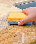 Hand using Chamois And Microfiber Cleaning And Polishing Pad For Countertops And Sinks 4 Inch By 1.75 Inch on stone surface