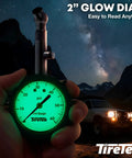 Tire pressure gauge with glowing green analog dial, front view; TireTek brand for cars.