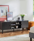 Mid Century Modern TV Stand For 55 To 60 Inch TVs With Storage, wooden black finish, two cabinets with soft close doors in a living room.