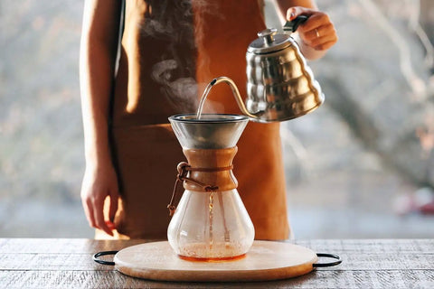 Person using Reusable Stainless Steel Pour Over Coffee Filter for Chemex and Hario V60 Drippers on wooden table