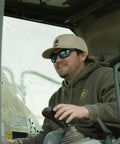 Kickass Z87 Certified Wayfarer Safety Sunglasses Featuring Hella Effective Antifog Smoke Lenses And Totally Shatterproof Matte Black Frames Built Tough For Male Workers, worn by a worker in a vehicle.