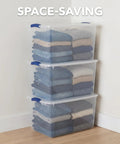 Hella Tough 66 Quart Clear Plastic Storage Bins With Secure Twist Latches And Smart Stack Design holding folded clothes in a stack.
