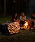 Curved Firewood Rack For Indoor And Outdoor Use, Heavy Duty Metal Log Holder With Detachable Haul Bag near a campfire
