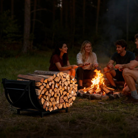Curved Firewood Rack For Indoor And Outdoor Use, Heavy Duty Metal Log Holder With Detachable Haul Bag near a campfire