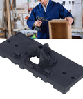 Close-up of a black plastic 35mm hinge jig drilling guide plate for woodworking.