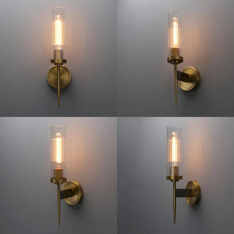 Slick Antique Brass One Light Bathroom Vanity Wall Sconce With Two Point Eight Inch Cylinder Ribbed Clear Glass Canopy shown lit.