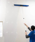 Person using ProSkim Handle Bracket Clamp On For Drywall Finishing Tool With All Angle Adjustment Fits ProSkim Blade on wall