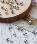 Antique Silver Tibetan Style Pumpkin Spacer Beads 4mm, 100 Piece Set for DIY Jewelry Making on wood and paper background