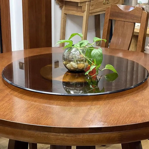 Brown Round Tempered Glass Lazy Susan Turntable for Dining Table with plant centerpiece, 360 degree rotation feature.